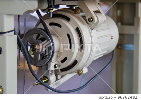Industrial sewing machine motor under the table, close-up. Industrial sewing machine motor under the table, close-up. 96362482