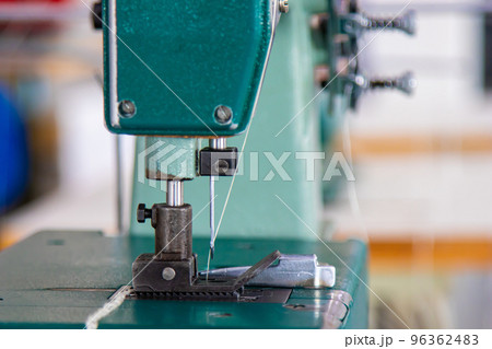 Sewing machine close-up: presser foot, needle, feed dog 96362483