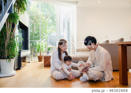 赤ちゃんに絵本の読み聞かせをする両親 96362668