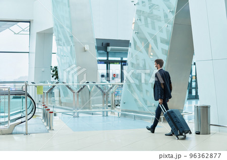 business man with luggage walking to the escalator . 96362877
