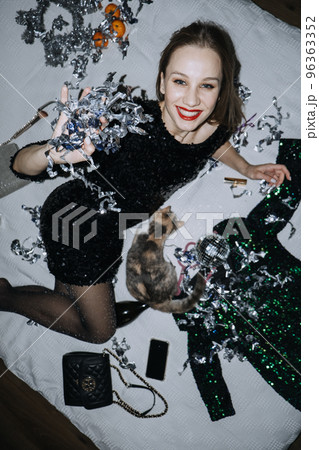 New year Eve home party ideas. Celebrate New Years Eve at Home. Happy young beautiful woman smiling, blows off sequins confetti and celebrating with champagne. Fun celebration of new year New year Eve home party ideas. Celebrate New Years Eve at Home. Happy young beautiful woman smiling, blows off sequins confetti and celebrating with champagne. Fun celebration of new year 96363352