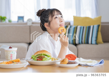 チートデイ　ドーナツを手に微笑む若い女性 96363705