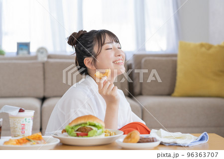 チートデイ ドーナツを手に微笑む若い女性 チートデイ ドーナツを手に微笑む若い女性 96363707