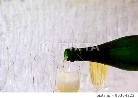 pooring champagne into a champagne flute 96364222
