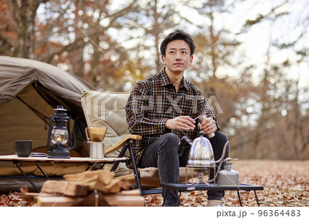 ソロキャンプを楽しむ若い日本人の男性 96364483