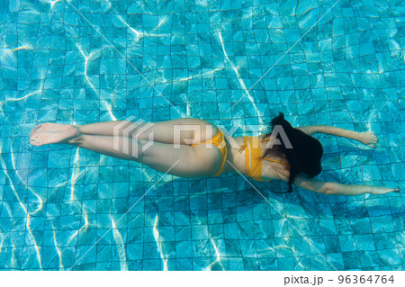 The girl dives under the water in the pool The girl dives under the water in the pool 96364764