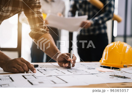 Working as a team architect and designer working on blueprint project of new apartments. Photo concept of work on technical drawings in office. Working as a team architect and designer working on blueprint project of new apartments. Photo concept of work on technical drawings in office. 96365057