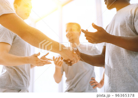 close up. two comrades shaking hands, standing in a circle of friends 96365378