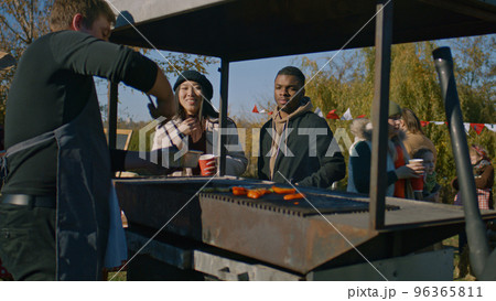 Multi ethnic family trying food cooked on grill Multi ethnic family trying food cooked on grill 96365811