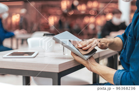 man in a protective mask processing personal belongings with antiseptic man in a protective mask processing personal belongings with antiseptic 96368236