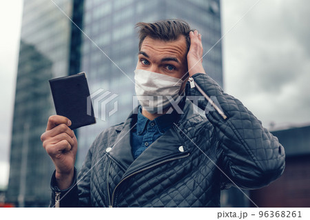 close up.a thoughtful man in a protective mask with a personal passport close up.a thoughtful man in a protective mask with a personal passport 96368261