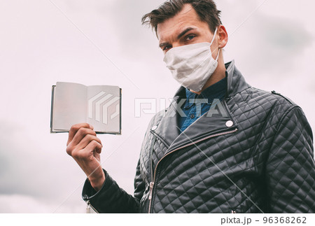 close up. a man in a protective mask showing his passport. close up. a man in a protective mask showing his passport. 96368262