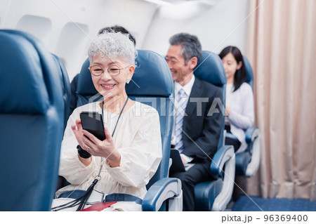 飛行機でスマホを使うシニア女性 飛行機でスマホを使うシニア女性 96369400