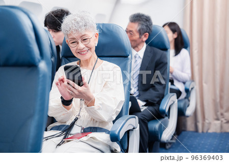飛行機でスマホを使うシニア女性 96369403