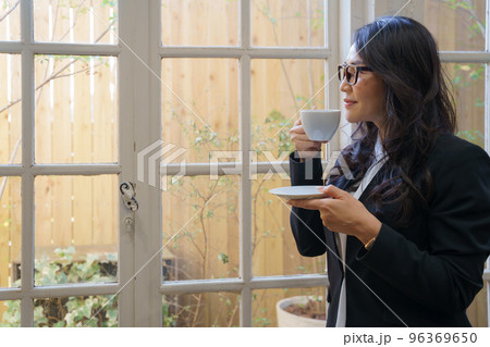 窓の外を眺めながらお茶を飲む女性 窓の外を眺めながらお茶を飲む女性 96369650
