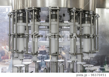 Industrial bottling machine at modern wine factory. Automatic conveyor line for wine-producing Industrial bottling machine at modern wine factory. Automatic conveyor line for wine-producing 96370451