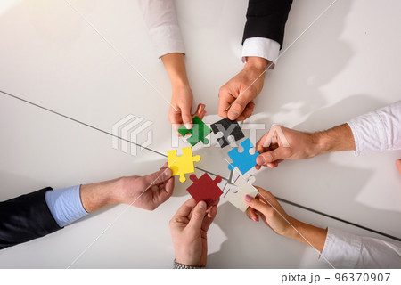 Teamwork of partners connect puzzle pieces as integration and startup 96370907