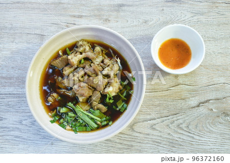 braised pork in herb brown soup on bowl and spicy chili sauce  96372160