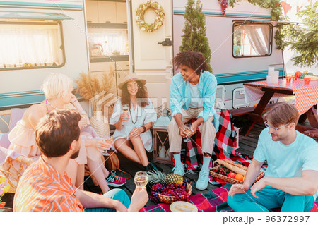 Friends have a picnic with a camper in a sunny day Friends have a picnic with a camper in a sunny day 96372997