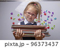 optimistic Little beautiful smiling girl holding books 96373437