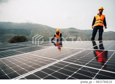 Workers assemble energy system with solar panel for electricity Workers assemble energy system with solar panel for electricity 96376810