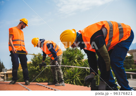 Team of technical workers work on the roof of a house 96376821