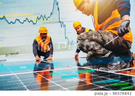 Workers assemble energy system with solar panel for electricity 96376842
