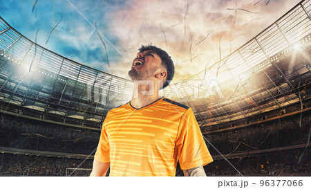 Soccer player in yellow uniform rejoices for the victory at the stadium 96377066
