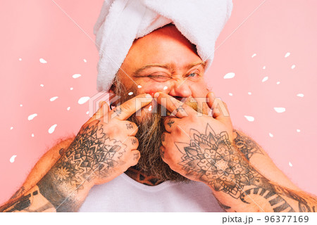 Man with beard and towel above the head squeezes a pimple Man with beard and towel above the head squeezes a pimple 96377169