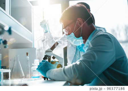 Doctor in the laboratory analyzes samples of codiv-9 under a microscope Doctor in the laboratory analyzes samples of codiv-9 under a microscope 96377186