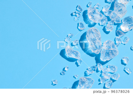 Close up crushed ice in sunlight on blue with copy space. Summer background refreshment concept 96378026