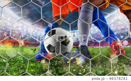 Soccer player kicks the ball to reach the goal 96378281