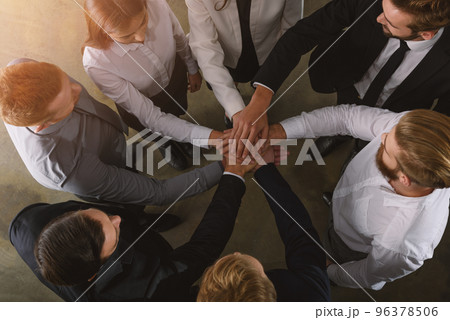 Business people putting their hands together as teamwork and partner 96378506