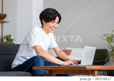 自宅でパソコンを使う若い男性 96378917