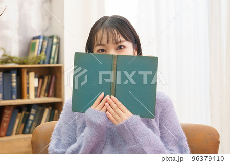 目から下を本で隠す若い女性 目から下を本で隠す若い女性 96379410