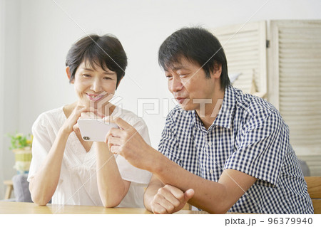 家でスマホを見る熟年夫婦 家でスマホを見る熟年夫婦 96379940