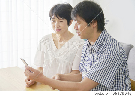 家でスマホを使う熟年夫婦 家でスマホを使う熟年夫婦 96379946