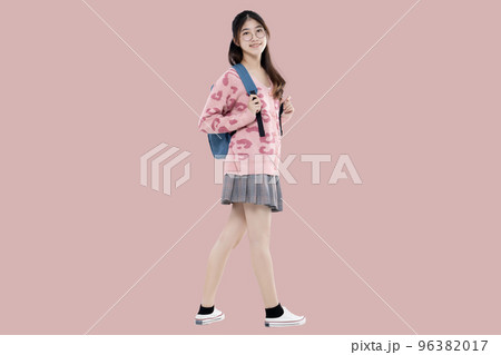 Happy Asian ethnicity teen girl hold backpack standing isolated on pastel pink background. Education in high school college concept. Happy Asian ethnicity teen girl hold backpack standing isolated on pastel pink background. Education in high school college concept. 96382017