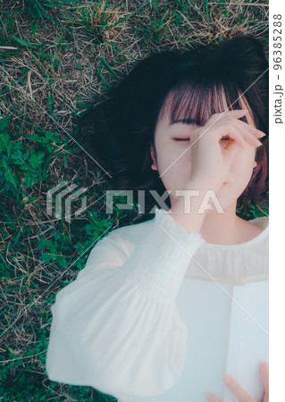寝そべって本を読む若い女性の写真 96385288