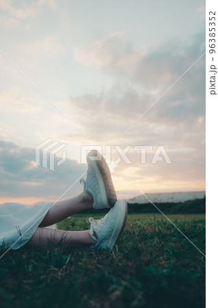 寝そべって足を組む若い女性の写真 96385352