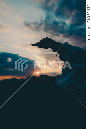 寝そべって音楽を聴く若い女性のシルエット写真 寝そべって音楽を聴く若い女性のシルエット写真 96385456