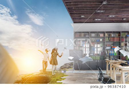 Kids wearing virtual reality goggles 96387410