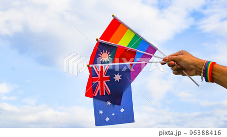 LGBT rainbow flag holding by hand with blue sky in background to enhance LGBTQ community around the world LGBT rainbow flag holding by hand with blue sky in background to enhance LGBTQ community around the world 96388416