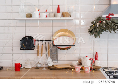 White festive kitchen - tiles on the wall, white refrigerator, red decor elements. Christmas home design. 96389740