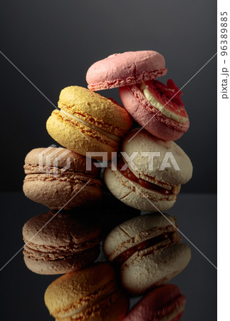 Delicious colorful macaroons on a black reflective background. Delicious colorful macaroons on a black reflective background. 96389885