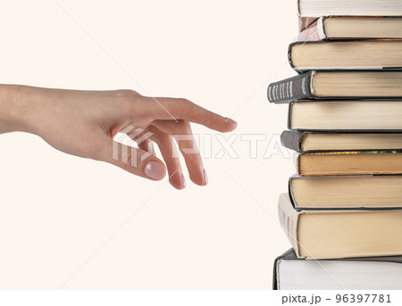 Woman hand selecting or pointing to book from stack isolated on white background. Book choice for reading. Woman hand selecting or pointing to book from stack isolated on white background. Book choice for reading. 96397781