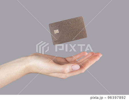 Woman hand and levitating plastic bank or debit card. Cashless payment and booking , making purchases on credit 96397892