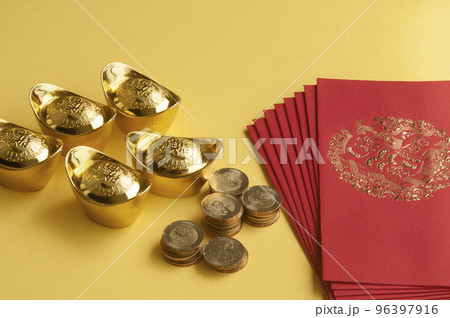 Happy Chinese New Year concept - Red packets with Chinese Golden Ingots and coins on yellow background with customizable space for text Happy Chinese New Year concept - Red packets with Chinese Golden Ingots and coins on yellow background with customizable space for text 96397916