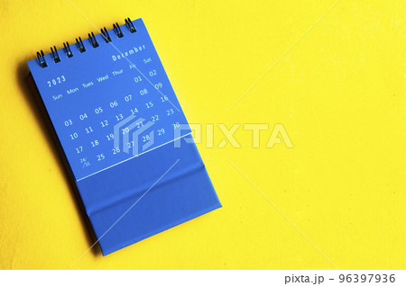 December 2023 blue desk calendar on yellow cover background with customizable space for text. Year end concept. 96397936