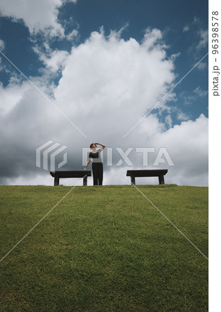 Happy young woman look at faraway when her relaxing in the park wiith clue sky and cloud Happy young woman look at faraway when her relaxing in the park wiith clue sky and cloud 96398578